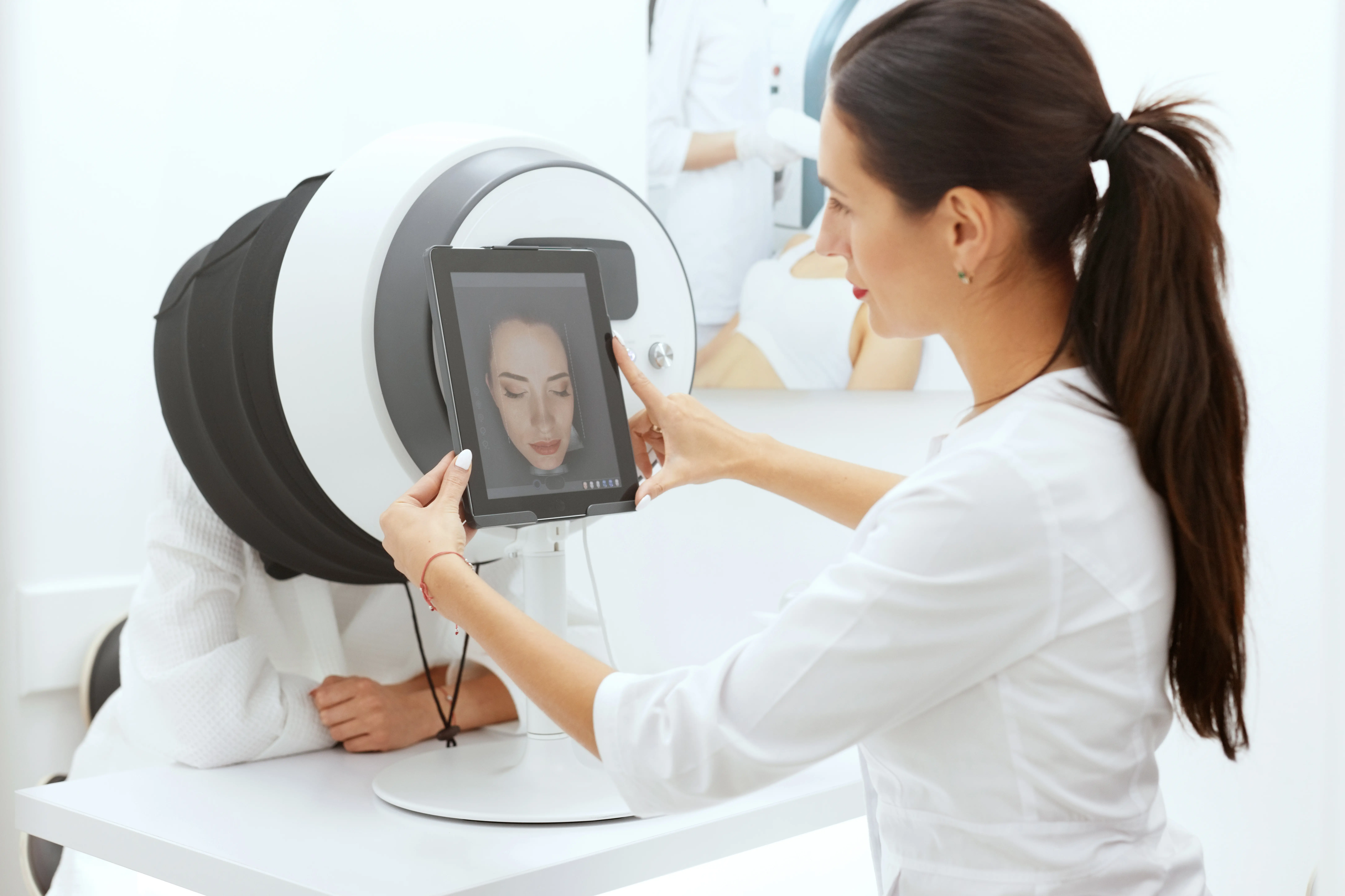 Woman in white coat analyzing skin scan results on a tablet